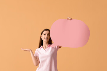 Wall Mural - Beautiful thoughtful young woman with speech bubble pointing at something on orange background