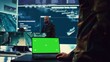 © DC Studio - Army officer studies isolated greenscreen display on a laptop in control room, military power base personnel monitoring satellite world map for federal operations. Commander in uniform. Camera B.