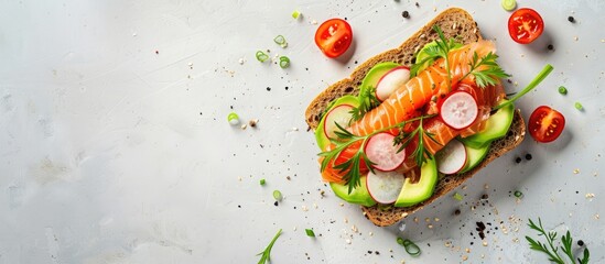 Canvas Print - Healthy fast food concept with a takeaway avocado and salmon sandwich on gluten-free grain bread, garnished with green onions, radishes, and tomatoes on a light background with copy space image.