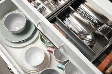 Wall Mural - Ceramic dishware and cutlery in drawers indoors, above view