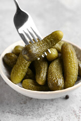 Wall Mural - Bowl with tasty pickled cucumbers on grey background