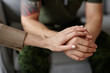 © Seventyfour - Close up of caring female therapist consoling army veteran holding his hand copy space