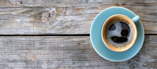 Poster - Bird's-eye view of a coffee cup on a textured wooden table, featuring a pleasing copy space image.