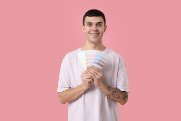 Canvas Print - Young man with paint palettes on pink background