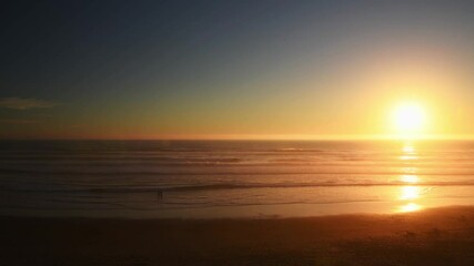 Wall Mural - Beautiful majestic glorious sunset on the Oregon pacific northwest coast with silhouetted people playing in the water