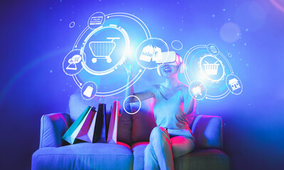 Smart female sitting on sofa while wearing VR headset connecting metaverse, future cyberspace community technology. Elegant woman enjoy open interface online store menu shop product. Hallucination.