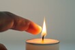 © Yuliia - Connection: a finger touching the candle flame
