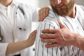 Canvas Print - Sports injury. Doctor examining patient's shoulder in hospital, closeup