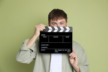 Poster - Making movie. Man with clapperboard on green background