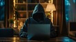 © ศิริธัญญา ตันสกุล - A man wearing a hoodie is sitting at a desk with a laptop