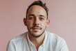 © Stocknterias - Portrait of a handsome young man in a white shirt on a pink background