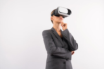 Wall Mural - Businesswoman thinking about marketing plan while wearing VR glasses at white background. Manager checking at financial graph while using visual reality goggles. Innovation technology. Contraption.