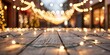 © Pual GotoMars - Festive string lights illuminating a charming street with a wooden table in the foreground, creating a cozy and warm atmosphere.