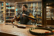 © Nomad_Soul - Man working in weapon shop preparing high quality munitions for sale