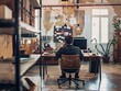 © Vitalii Shkurko - A man sits at a desk in a stylish, modern office with industrial decor, focusing on his computer screen. back view