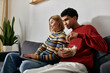 © LIGHTFIELD STUDIOS - A happy, multicultural couple enjoys a movie night in their cozy, modern apartment.