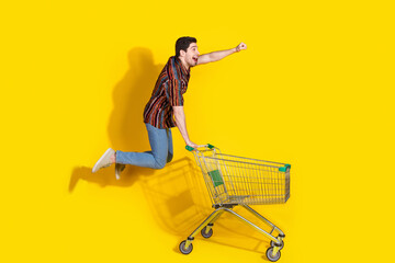 Poster - Full size photo of nice young man jump trolley empty space wear shirt isolated on yellow color background