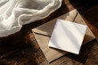 © Sandra Chia - Creative template concept. Square blank card note with envelope on dark wood table rustic background with white cloth and evening light shining. Mock up presentation
