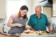 © NonVig/peopleimages.com - Elderly father, daughter and cooking in kitchen for lunch with bread slice, fruit and wellness food for retirement. Senior dad, woman and prepare cheese platter in home for diet, nutrition and health