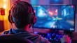© Helga P-A. - Cyber sport young man gamer wearing headphones playing video game at computer in neon light view from behind. The concept of cybersport