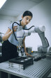 © Nassorn - Computer science development engineer working on robotic arm connection control at electronic futuristic technology academy. Modern hispanic woman training smart industry 4.0 automatic engineering.