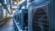 © khonkangrua - Row of industrial HVAC units inside a modern facility, showcasing cooling and ventilation systems in an industrial setting.