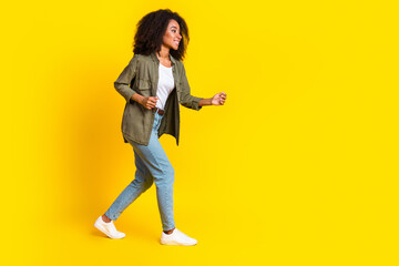 Sticker - Full size photo of funny positive girl dressed khaki jacket jeans look at offer go empty space isolated on yellow color background