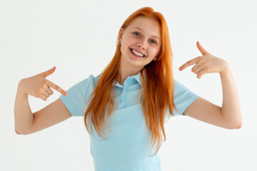 Wall Mural - Young woman standing over white background looking confident with smile on face, pointing oneself with fingers proud and happy