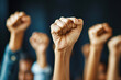 © Uwe - Close up of multiethnic people's hands raising fists in the air, with strong wrists showing the spirit of struggle and solidarity