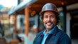 © Favio - 40s Hispanic man, engineer, wearing a hard hat, standing in front of a house under construction.