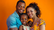 © BetterPhoto - A family of three smiling against an orange background. They are dressed in casual clothing and look happy and close