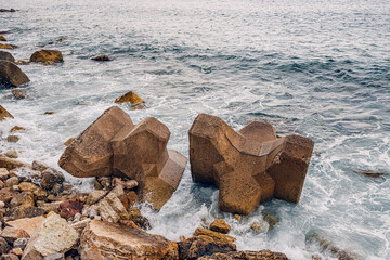 Wall Mural - Breakwater along the coast, protecting the beach with its rugged rocks and calming seascape