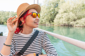 Wall Mural - Cheerful woman in sunglasses and hat, exploring the scenic landscape of Lake Skadar.