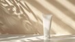 © TheWaterMeloonProjec - Minimalistic mockup of white tube on gentle warm background with light and shadow Space for copy ideal for beauty blogging and skincare