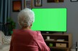 © CogniLens - Display mockup from a shoulder angle of a senior woman in front of an smart-tv with a completely green screen