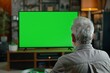 © CogniLens - App display looking over a shoulder of a senior man in front of an smart-tv with an entirely green screen