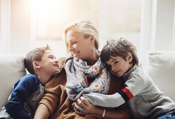 Wall Mural - Happy, relax and mother with children on sofa hugging, playing and bonding together at house. Smile, love and boy kids resting and embracing with mom on couch in living room at family home in Canada.