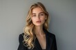 © Elena - Young Blonde Woman Wearing Black Blazer Against Grey Wall