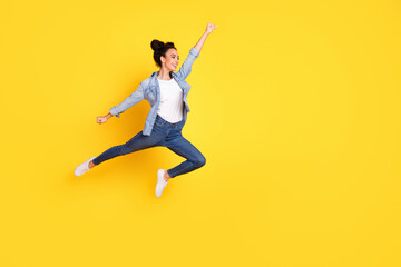 Wall Mural - Full body portrait of nice young girl jump empty space wear denim shirt isolated on yellow color background