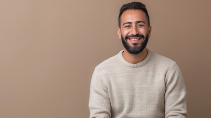 Middle Eastern male teacher with a beard smiling on a brown background, copy space. Smiling Bearded math Teacher on Beige Background.