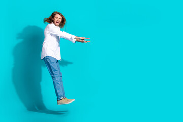 Canvas Print - Full length photo of attractive funny guy wear white shirt jumping high emtpy space isolated blue color background