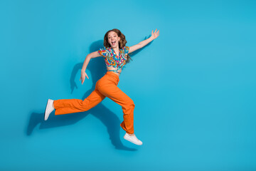 Wall Mural - Full body portrait of lovely young girl jump run empty space wear top isolated on blue color background
