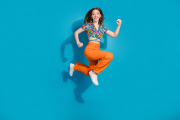 Wall Mural - Full body portrait of lovely young girl jump run wear top isolated on blue color background