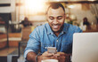 © ClearConcept/peopleimages.com - Man, cafe and happy typing on smartphone, smiling and message notification on mobile app with online searching. Communication, freelance writer and break in restaurant, social media and reading blog