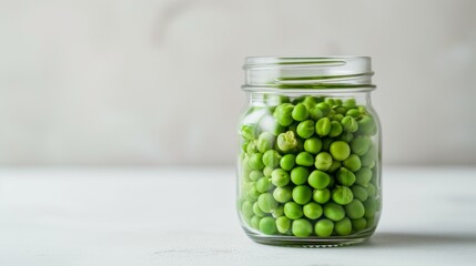 Wall Mural - Glass jar filled with closed green peas, placed on a smooth white surface