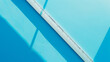 © Blue_Utilities - Close-up of a ruler casting shadows on a turquoise background