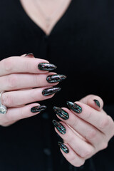 Wall Mural - Female hands with long nails and black manicure 
