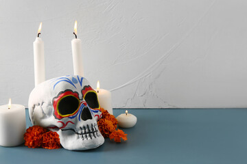 Poster - Painted skull with marigold flowers and candles on color background. Celebration of Mexico's Day of the Dead (El Dia de Muertos)