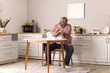 © Pixel-Shot - Portrait of sad senior man with tissues sitting at table in kitchen