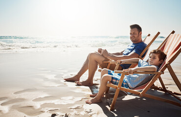 Poster - Happy, beach and father with kid on chair on holiday, vacation and relaxing on tropical island. Family, travel and dad with young boy by ocean for bonding, relationship and fun outdoors in nature